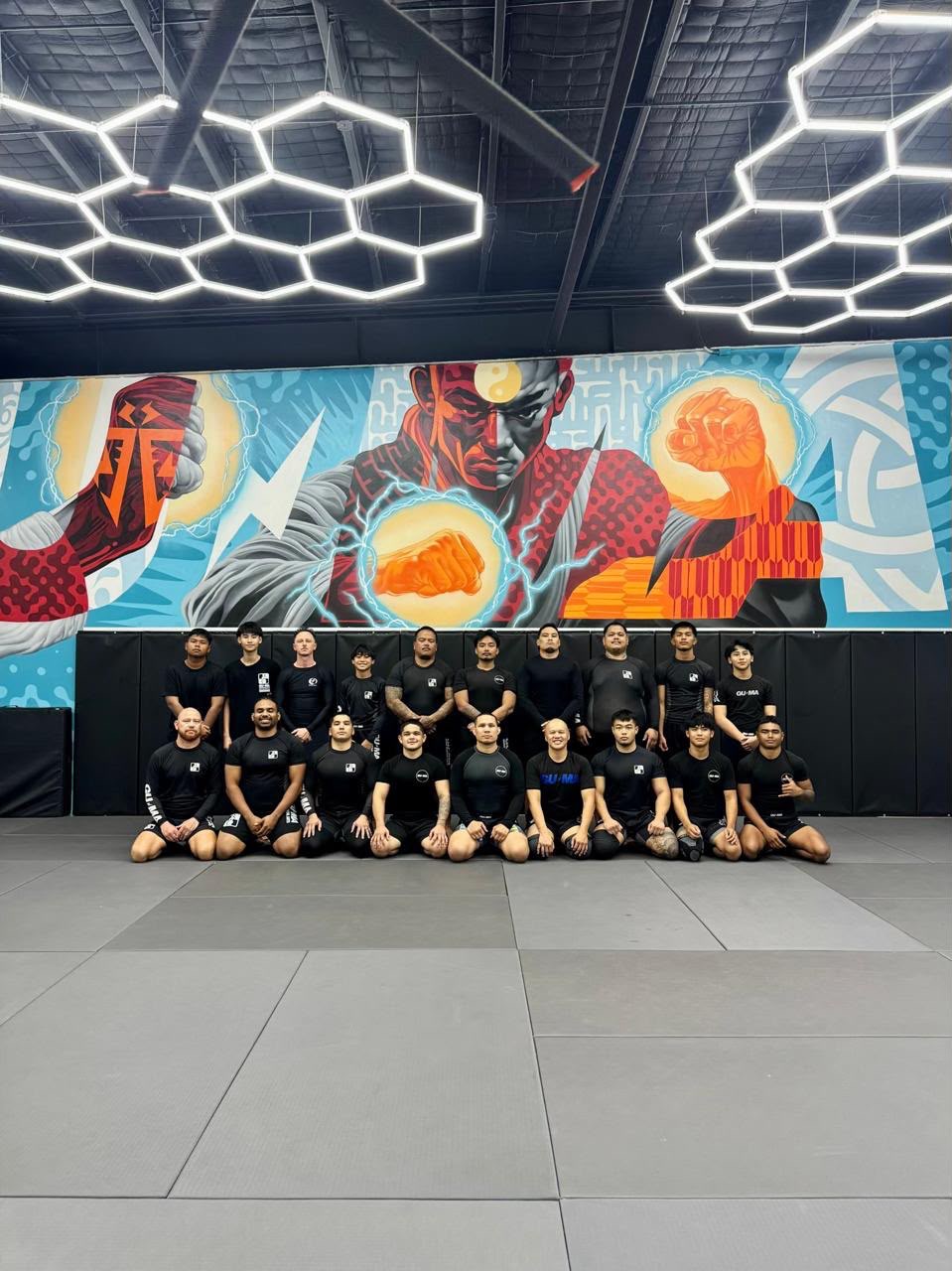 Jeffrey Bresch with the GUMA competition team in front of the gym mural