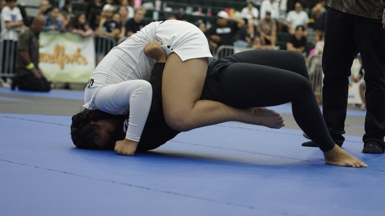Sophia Miranda working from top position in a white gi