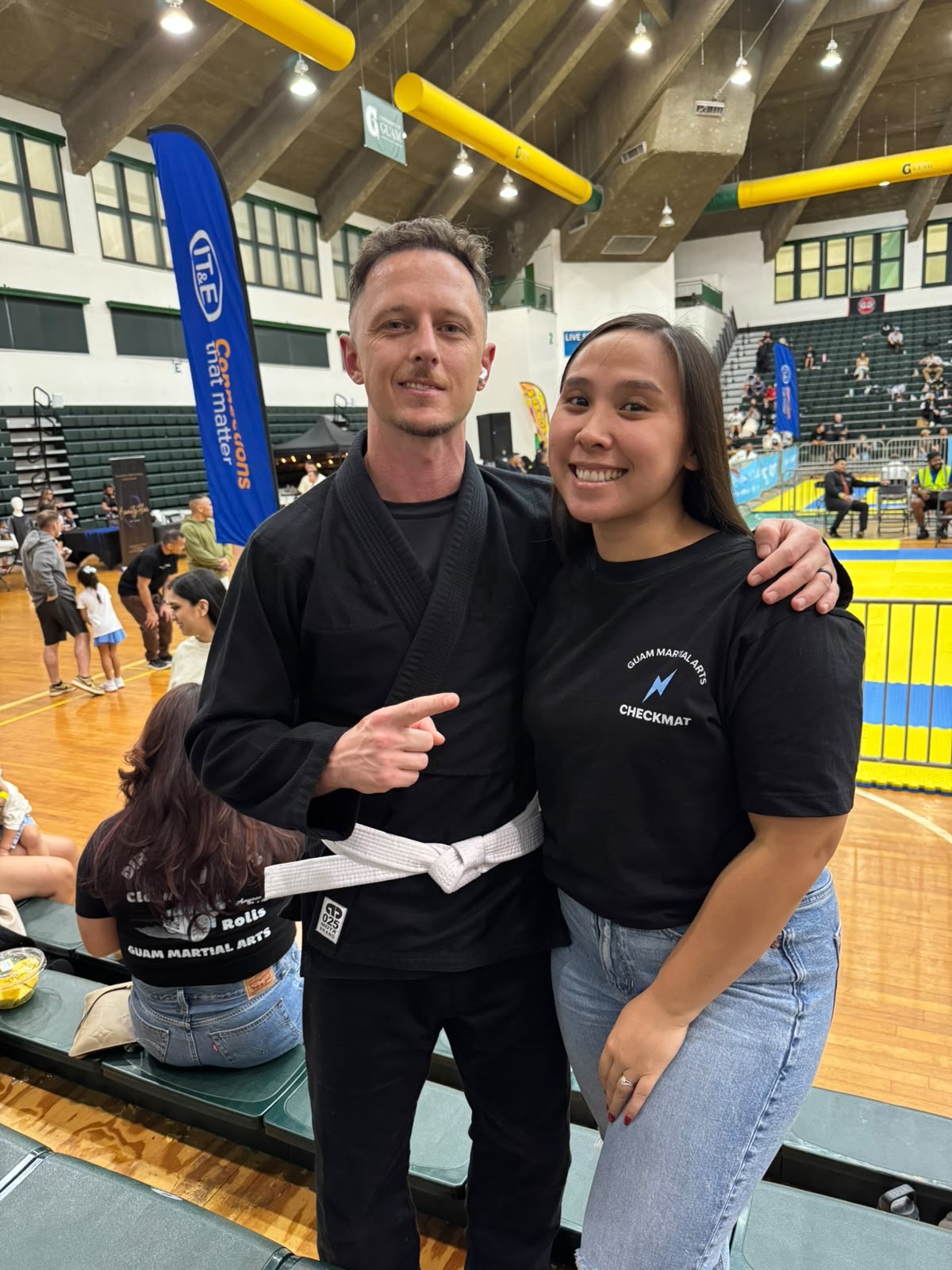 Jeffrey Bresch in his black gi with white belt at a tournament alongside a teammate