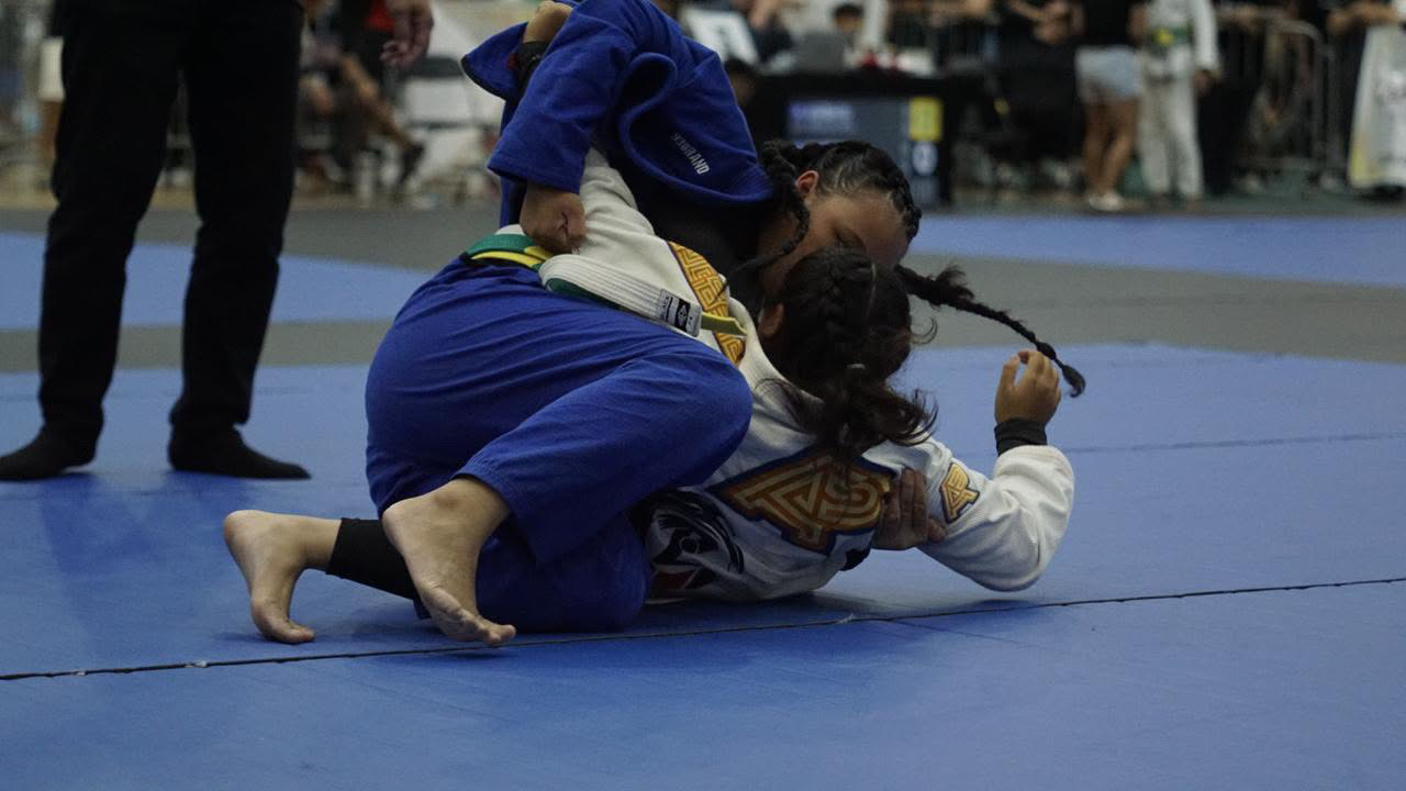 Sophia Miranda in a blue gi passing the guard