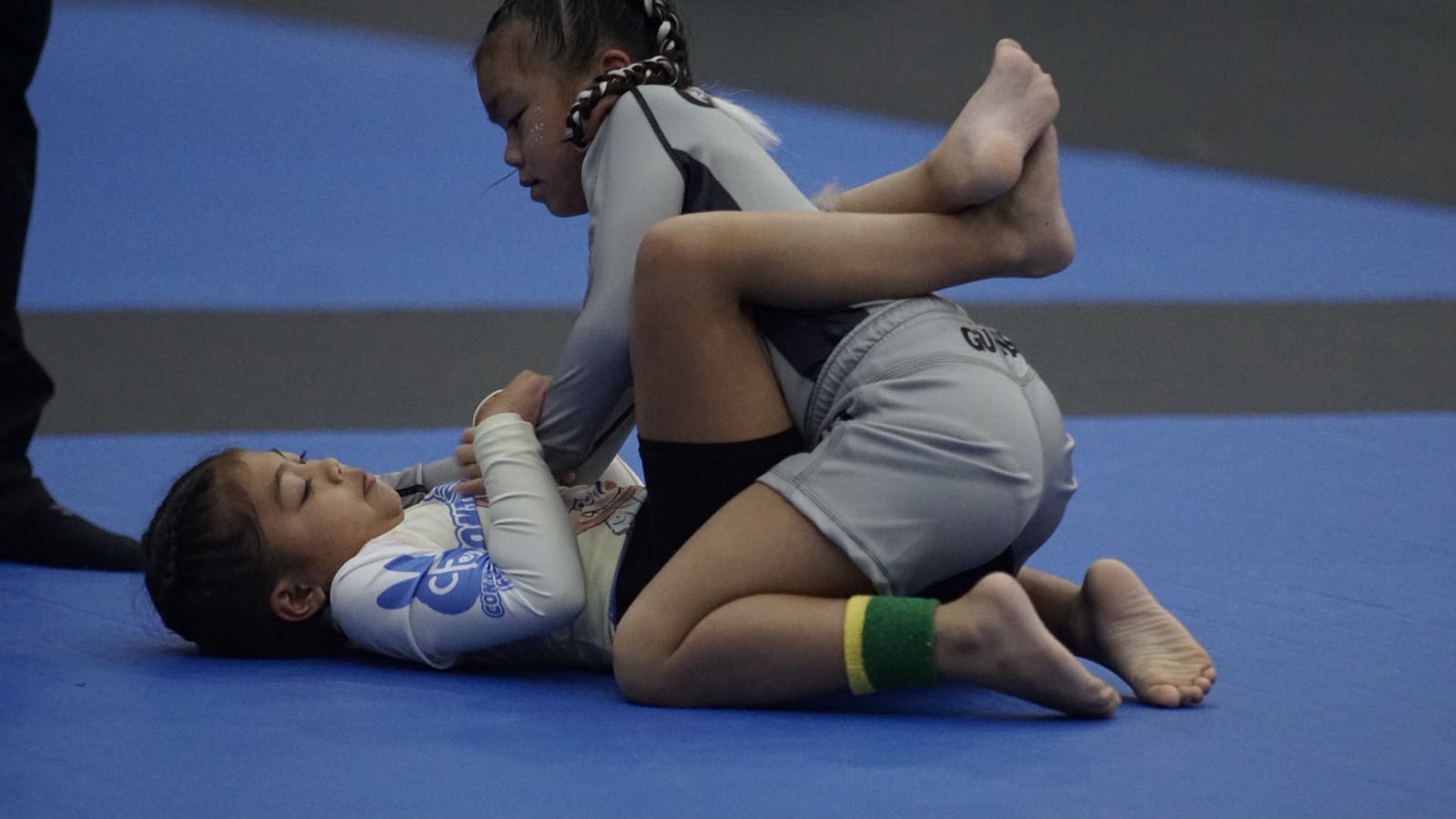 Ivy Sablan competing in a grey GUMA rashguard on the blue mat