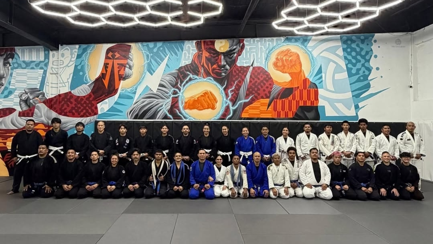 Anthony Salas with the GUMA team in front of the academy mural