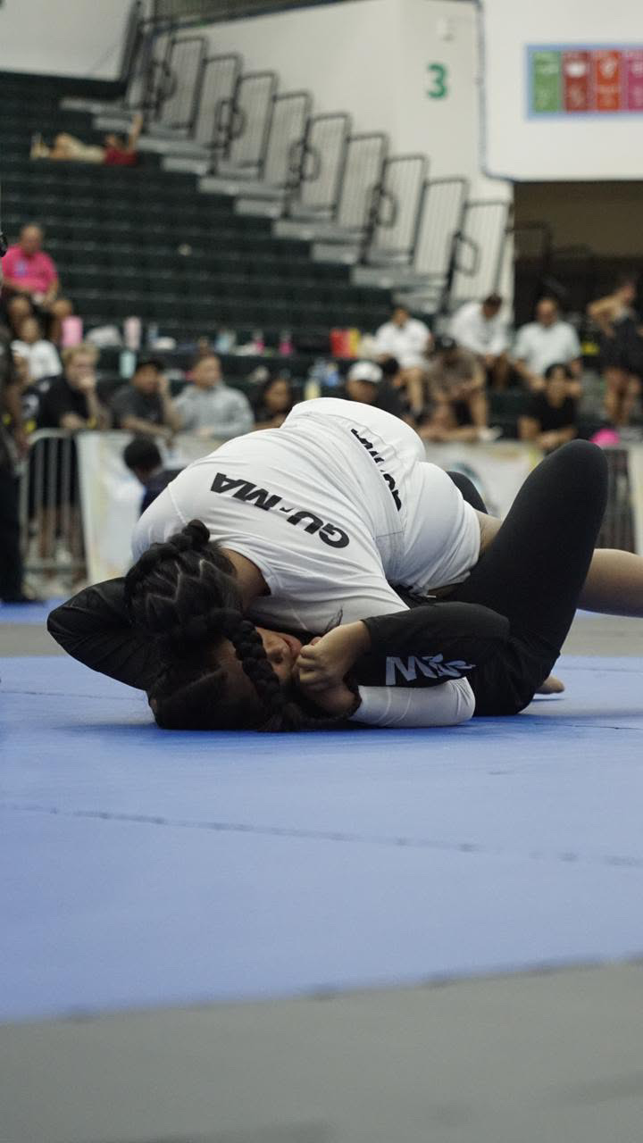 Sophia Miranda in a white rashguard on top of her opponent