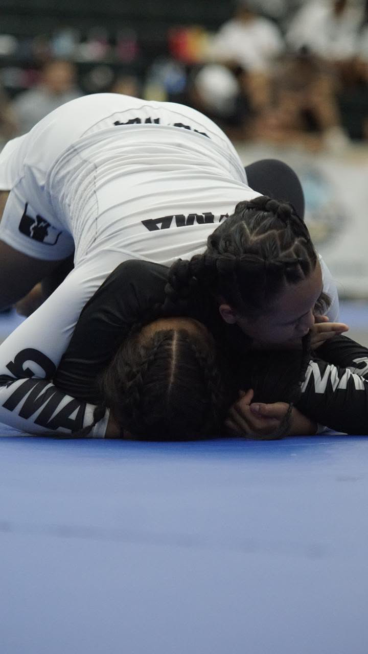 Sophia Miranda in a black rashguard controlling her opponent