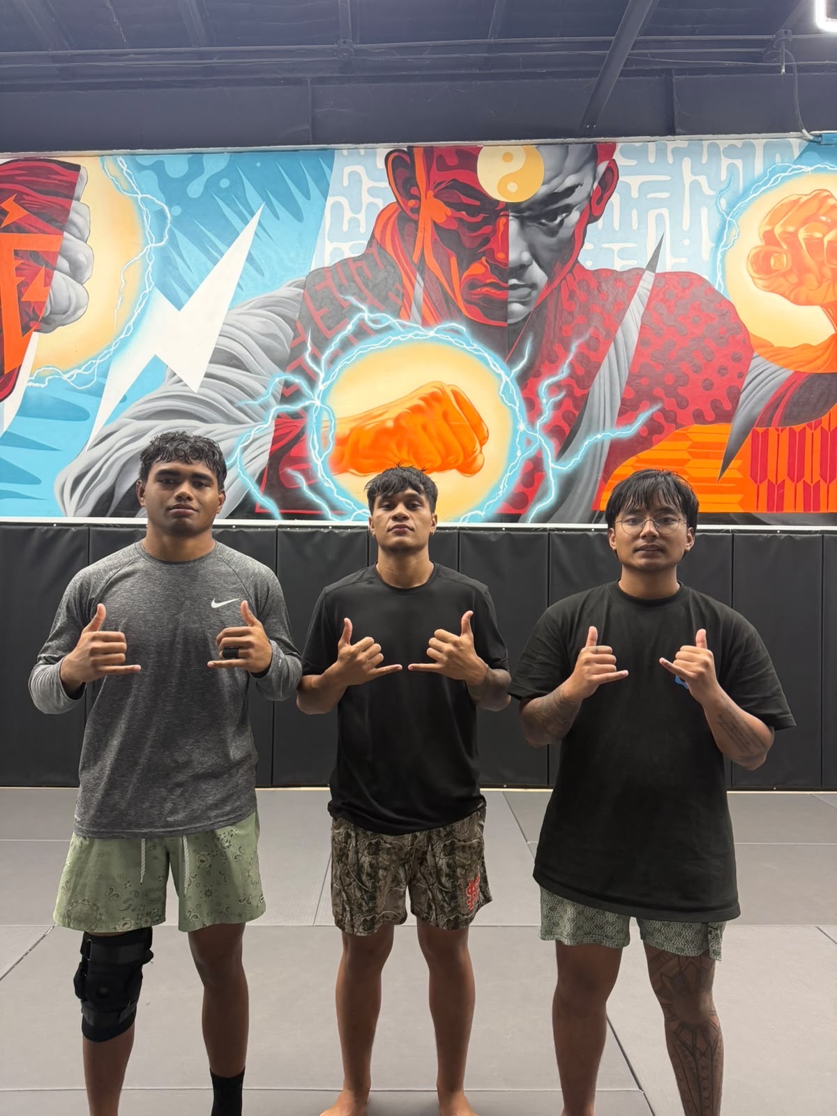 Jasper Alpet with GUMA teammates in front of the academy mural